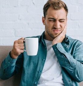 Man experiencing sensitivity to hot coffee