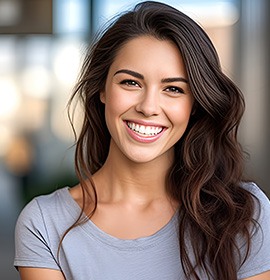 Closeup of woman in grey shirt smiling outside