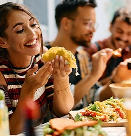 Woman smiling while eating lunch with friends at restaurant