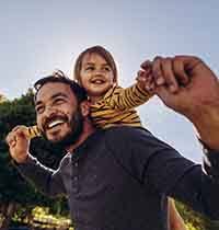 Man holding toddler outside 