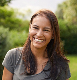 Older woman wearing gray sweater and smiling