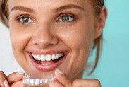 Smiling Person holding Invisalign 