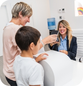 Parent and child at front desk of dental office