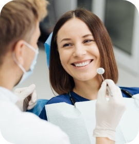 Female patient smiling at dentist holding mirror