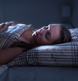 Woman with sleep apnea in Brampton, ON lying in bed snoring