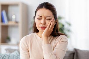 Woman sitting on couch with toothache